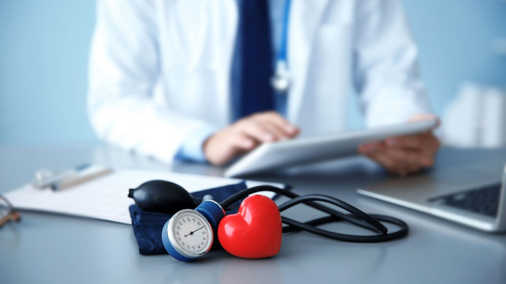 A healthcare provider sitting at a desk and studying data on a clipboard